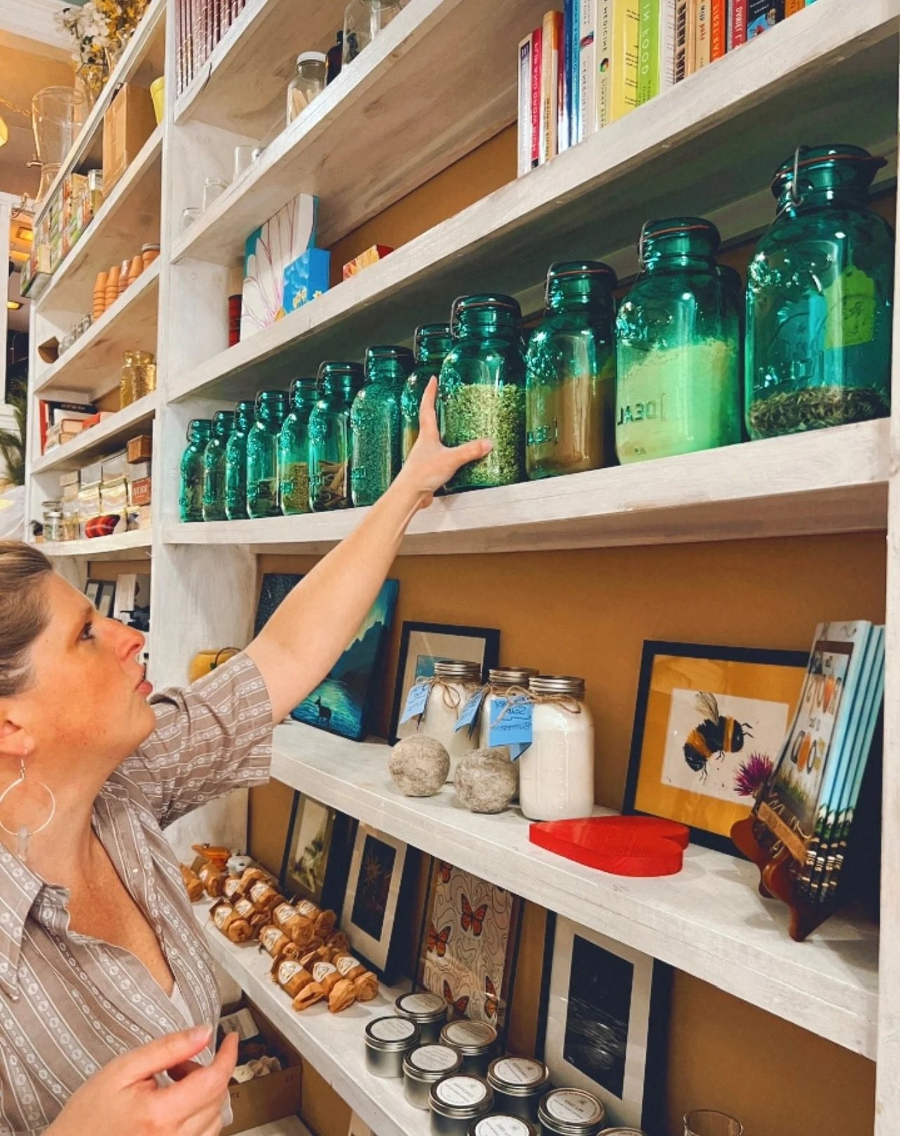 Reaching for a jar on the tall shelves inside the shop
